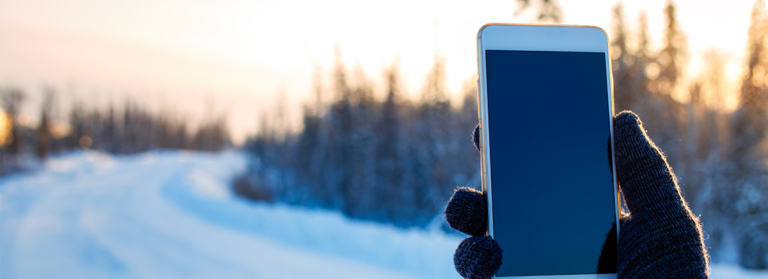 Jemand hält Handy in der Hand im Winter