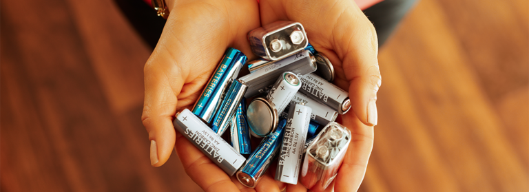 Jemand hält viele unterschiedliche Batterien in der Hand